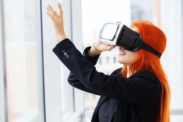 woman-virtual-reality-headset-pointing-air-while-her-working-place-office